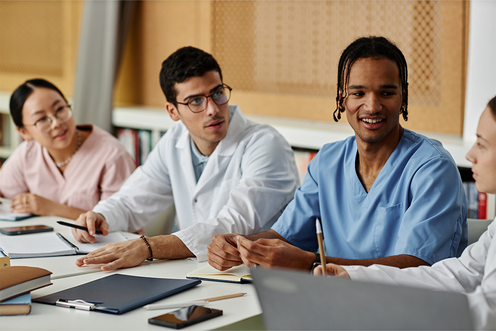Several doctors seated at a table, actively participating in a meeting, emphasizing their commitment to patient care and teamwork