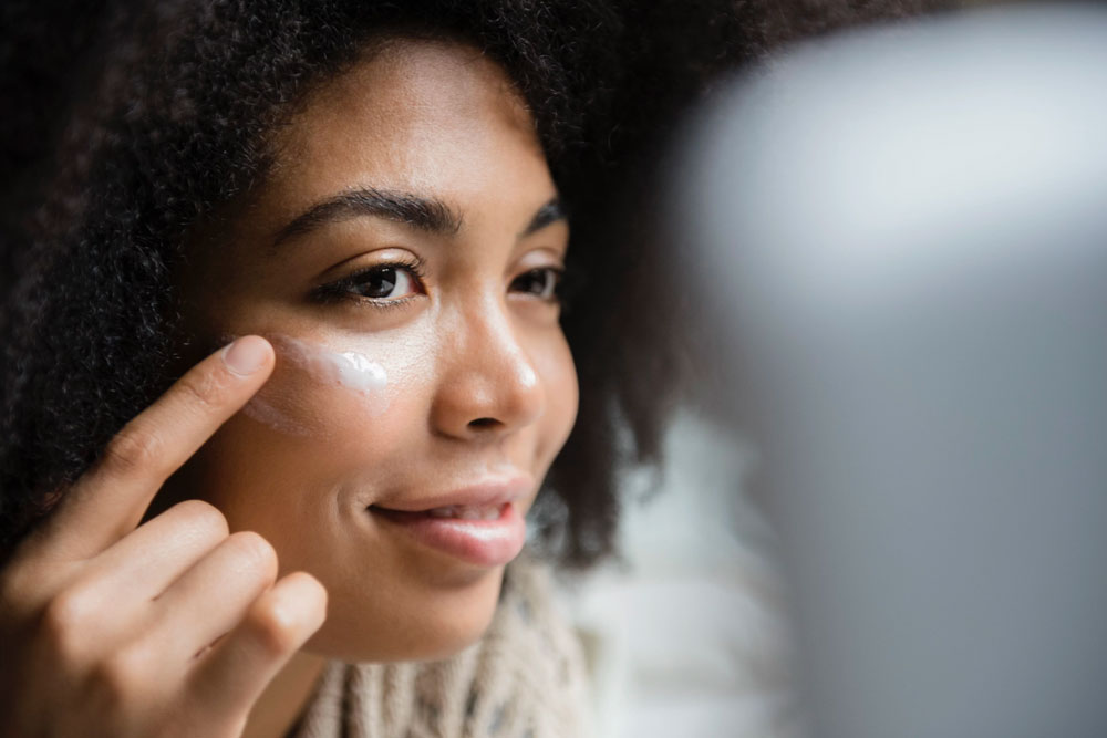 close up of woman's face with lotion around her eyes